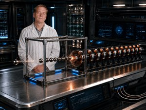 A scientist stands beside a futuristic magnetic induction array as sparks explode across a precision Newtons cradle. Copper coils, polished steel, glowing controls, and high-speed motion create a dramatic laboratory experiment, blending advanced engineering, cinematic realism, and imaginative science fiction into one striking poster-ready scene composition.